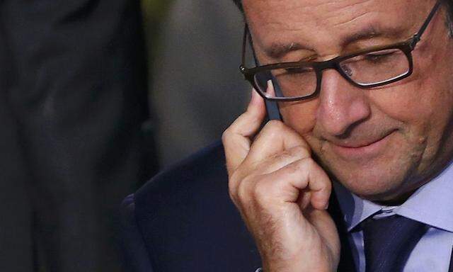 French President Francois Hollande uses his mobile phone as he attends the NATO summit at the Celtic Manor resort 