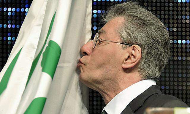 Former Northern League party leader and founder Umberto Bossi, kisses his party flag during a party r