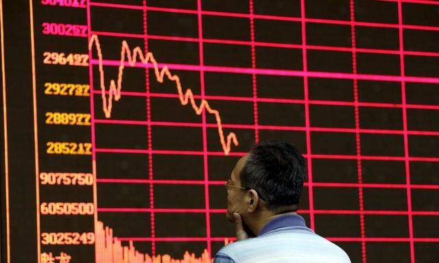 An investor looks at an electronic board showing stock information of Shanghai Stock Exchange Composite Index in Beijing