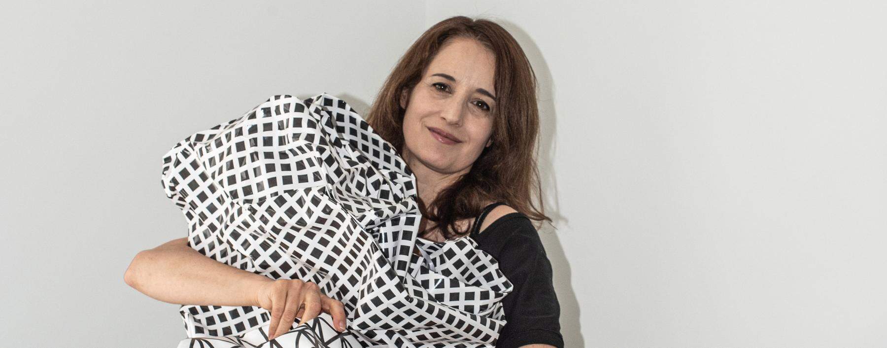 Die Künstlerin Esther Stocker auf einem Prototyp des „Knitter­planeten“, den die Firma Kohlmaier umsetzt.