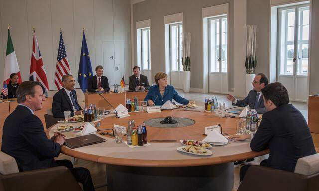 Top ranking officials sit at table before their meeting in Schloss Herrenhausen in Hanover
