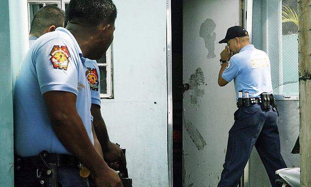Die Polizei vor dem Haus des Verdächtigen in Manila auf den Philippinen.