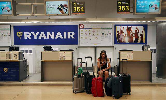 A stranded Ryanair passenger checks her phone at the Adolfo Suarez Madrid Barajas airport in Madrid
