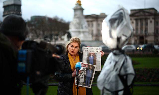 Eine Journalistin berichtet am Dienstag vor dem Buckingham Palace in London über Charles‘ Krebserkrankung.