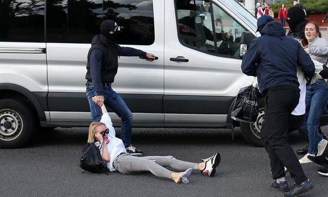 Beamte in Zivil verschleppen festgenommene Frauen in Minsk in unmarkierte Fahrzeuge und bringen sie weg.