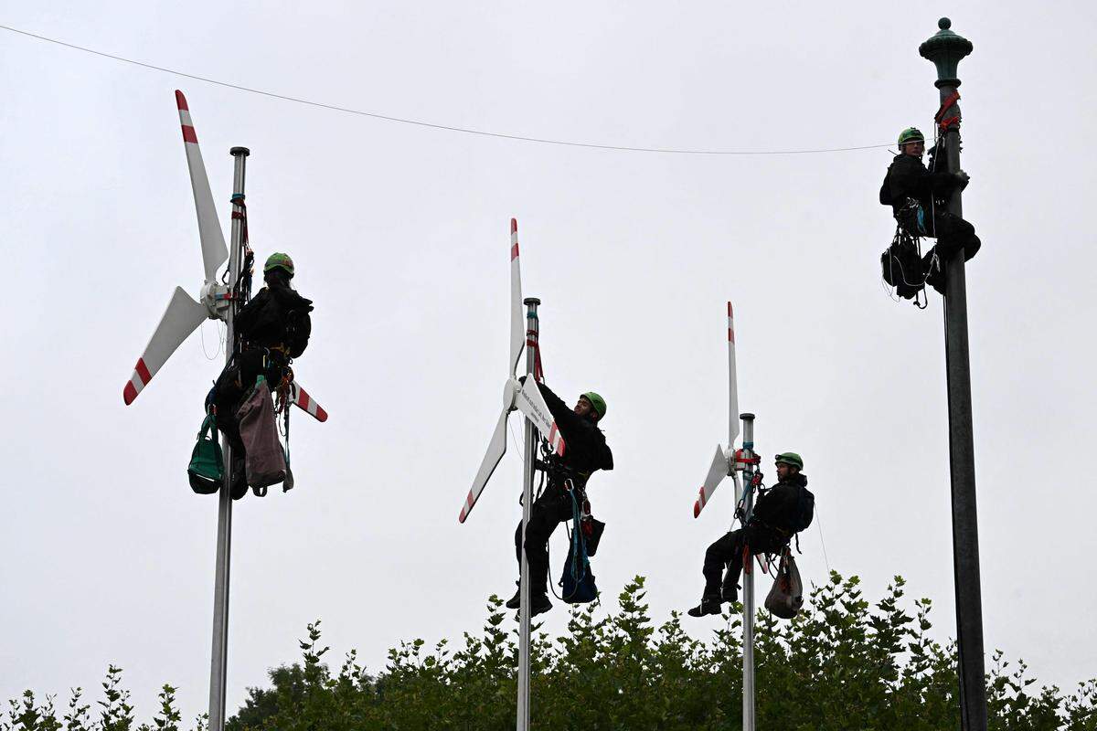 30. August. Greenpeace-Aktivisten klettern vor der Bayerischen Staatskanzlei in München auf Fahnenmasten, um Nachbildungen von Windkraftanlagen zu platzieren.