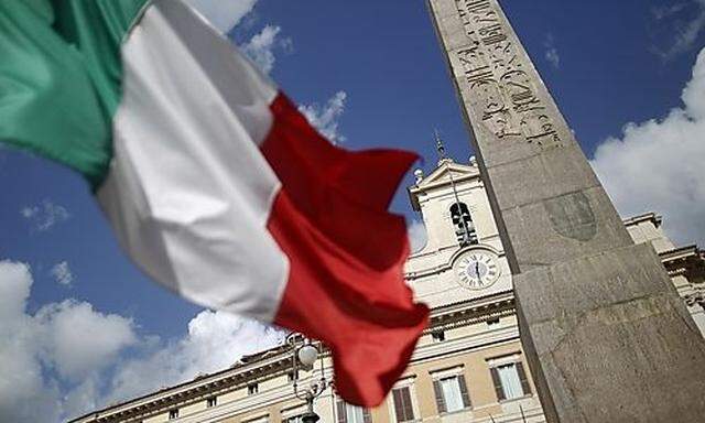 An Italian flag waves in front of the Montecitorio palace before the start of a finances vote in down