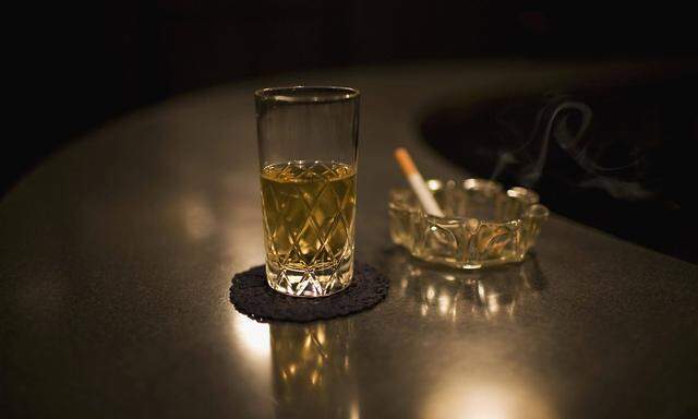 Glass of whiskey next to a cigarette in an ashtray PUBLICATIONxINxGERxSUIxAUTxONLY Copyright Aaronx