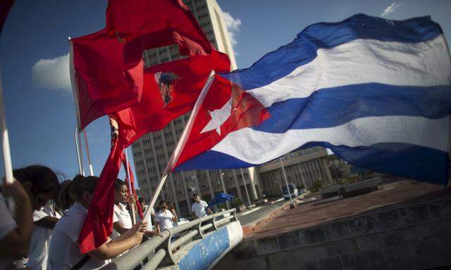 Students hold flags during a ceremony in Havana