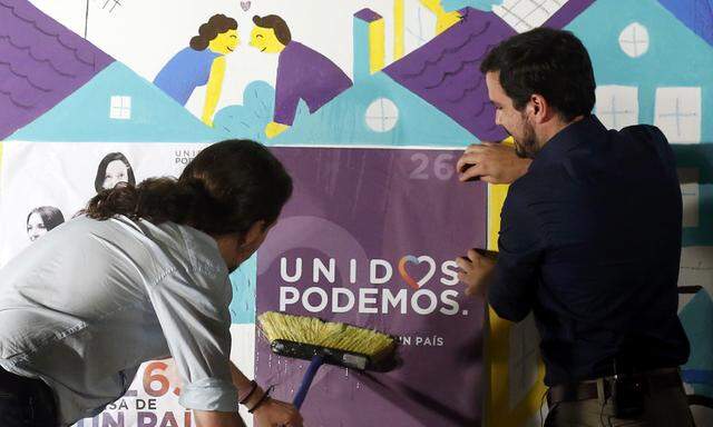 Podemos (We Can) leader Pablo Iglesias and Izquierda Unida (United Left) leader Alberto Garzon, of Unidos Podemos (United We Can) coalition, put up a campaign poster in Madrid