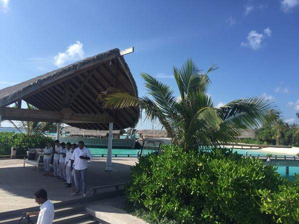 Herzlich willkommen: Mitarbeiter in weißer Livree begrüßen die neuen Gäste auf dem Bootssteg der Insel Milaidhoo.