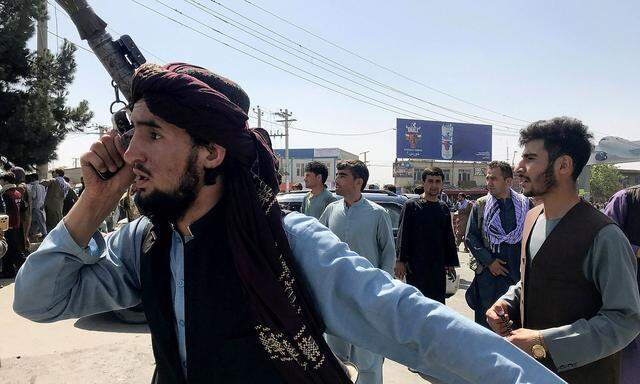 A member of Taliban forces inspects the area outside Hamid Karzai International Airport in Kabul