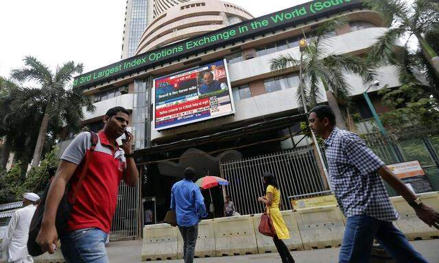 People look at a screen displaying India's FM Jaitley presenting the budget on the facade of BSE building in Mumbai