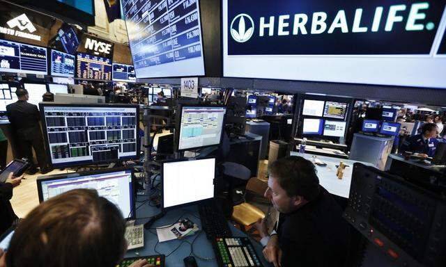 Traders work at the post that trades Herbalife stock on the floor of the New York Stock Exchange