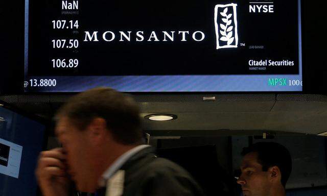A trader works at the post where Monsanto Co. is traded on the floor of the New York Stock Exchange (NYSE) in New York City