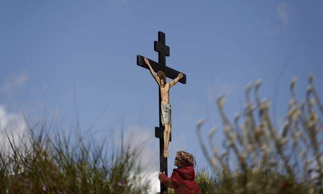 An boy kisses a crucifix on Good Friday at Penteli monastery, north of Athens