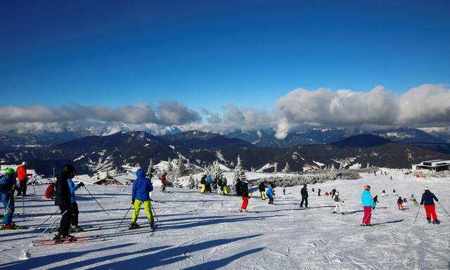 Skiers are on the slope on a sunny winter's day at the ski resort of Flachau