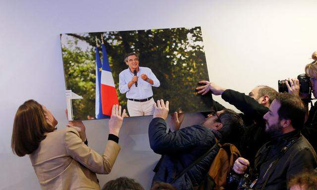 Sturz eines Polit-Stars: Journalisten hängen ein Foto Fillons auf, es war vor der Pressekonferenz auf den Boden gefallen.