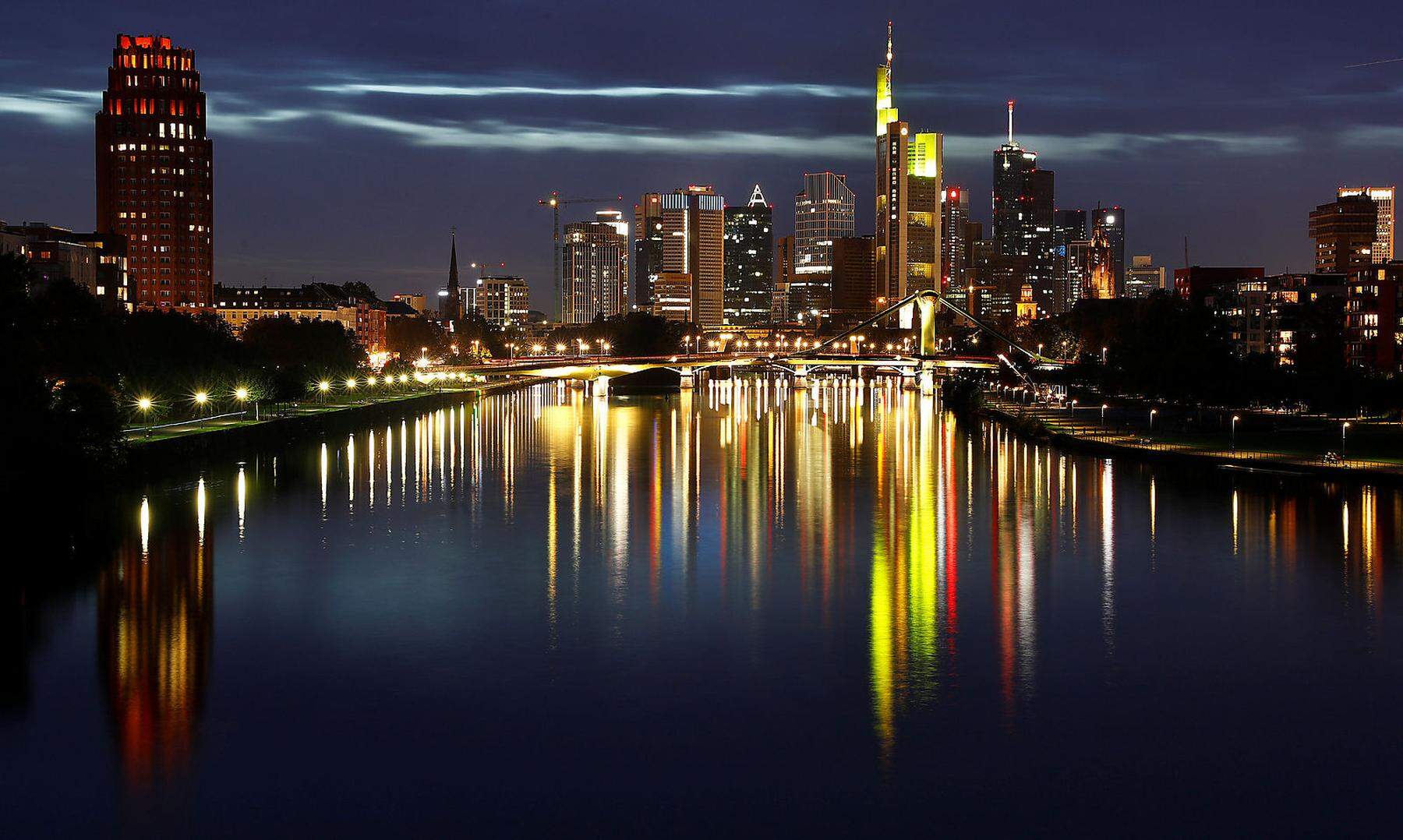 The skyline with its characteristic banking towers is reflected in river Main in Frankfurt