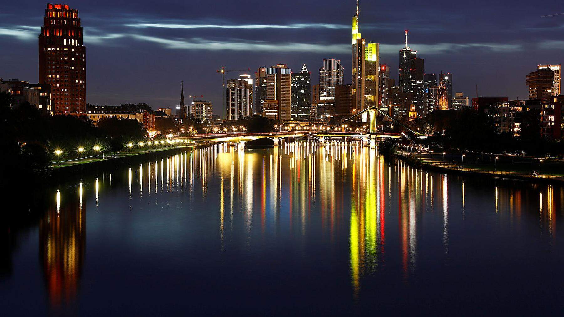 The skyline with its characteristic banking towers is reflected in river Main in Frankfurt