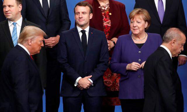 Vielsagende Blicke. Frankreichs Staatschef Macron und die deutsche Kanzlerin Merkel beobachten beim Nato-Gipfel die vorbeiziehenden Präsidenten Trump und Erdoğan. 