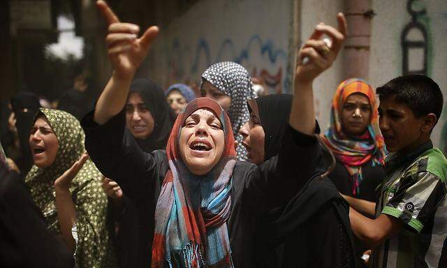 Relatives of Palestinian members of Al-Batsh's family, who hospital officials said were killed in an Israeli air strike, mourn during their funeral in Gaza City