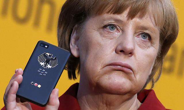 German Chancellor Merkel holds a BlackBerry Z10 smartphone featuring high security Secusite software at the booth of Secusmart during her opening tour at the CeBit computer fair in Hanover