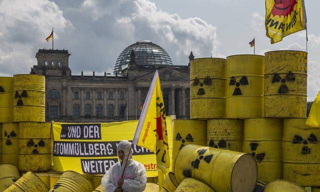 Environmental activists protest with mock nuclear waste barrels in front of the Reichstag in Berlin