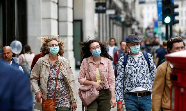 Passanten mit Mund-Nasenschutzmasken in London. 