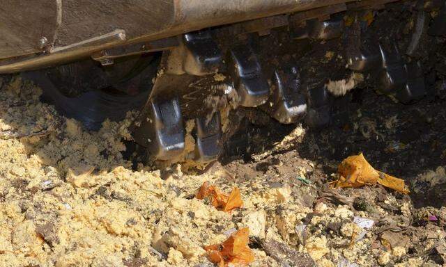 Handout photo of a bulldozer destroying illegally imported cheese falling under restrictions in Belgorod region