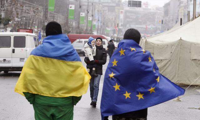 Zwei Männer mit der ukrainischen und der EU-Flagge.