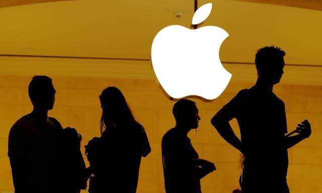 FILE PHOTO: Customers walk past an Apple logo inside of an Apple store at Grand Central Station in New York