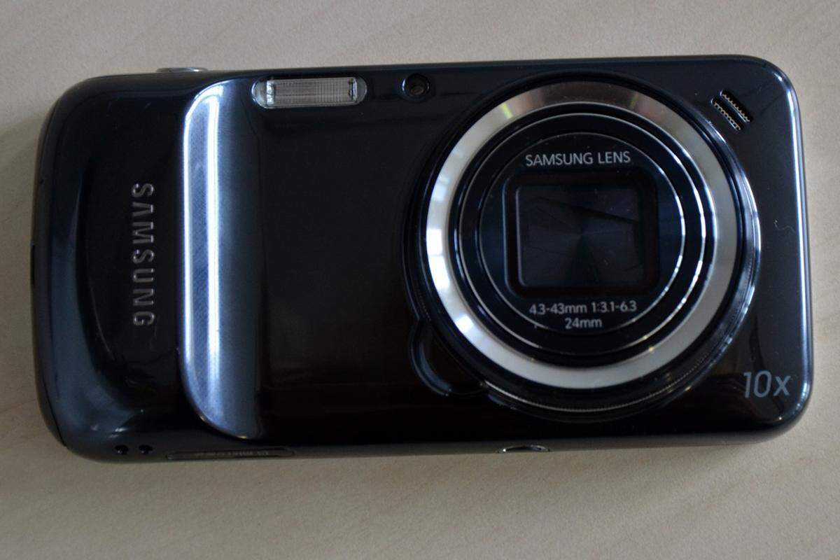 Dreht man das Smartphone um, sieht es aus wie eine herkömmliche digitale Kompaktkamera. Leider wirkt das oft kritisierte Kunststoffgehäuse von Samsung an einer Kamera besonders billig.