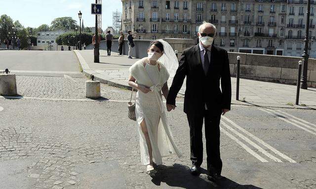 News Bilder des Tages A couple celebrating their wedding anniversary wear masks as they take a stroll in the near empty