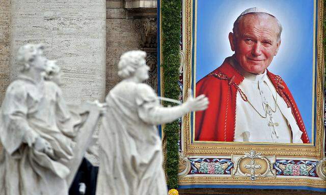 Tapestry portrait of Pope John Paul II hanging from the facade of St Peter's Basilica is seen across the colonnade roof during the canonisation ceremony at the Vatican
