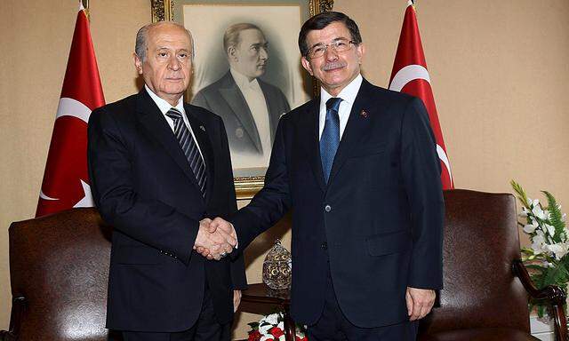 Turkey´s Prime Minister Davutoglu shakes hands with opposition Nationalist Movement Party (MHP) Leader Bahceli during a meeting as part of the coalition talks in Ankara, Turkey