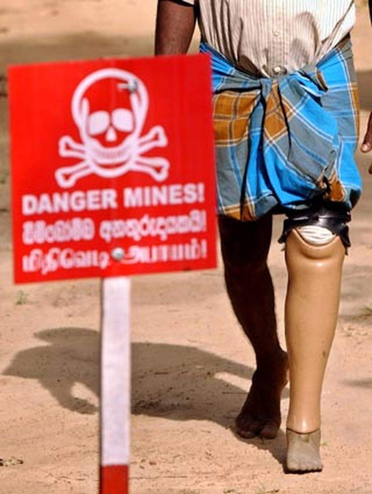 Die "Ottawa-Konvention" zum Verbot von Antipersonenminen trat am 1. März 1999 in Kraft und untersagt den Einsatz, die Herstellung, die Lagerung und den Handel von Antipersonen-Minen.  Im Bild: Minenopfer und Warnschild in Sri Lanka.