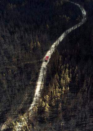 A fire truck drives across a forest burnt by wildfire towards to the sattelment of Zapasnoye in Chelyabinsk Region