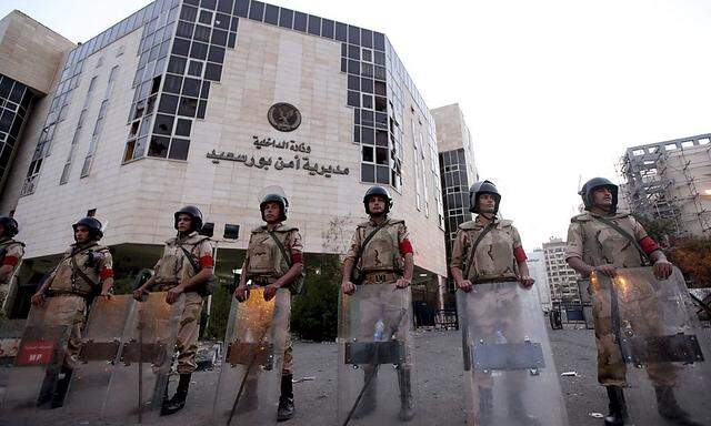Army soldiers stand guard in front of the Security Directorate after the withdrawal of police forces in Port Said