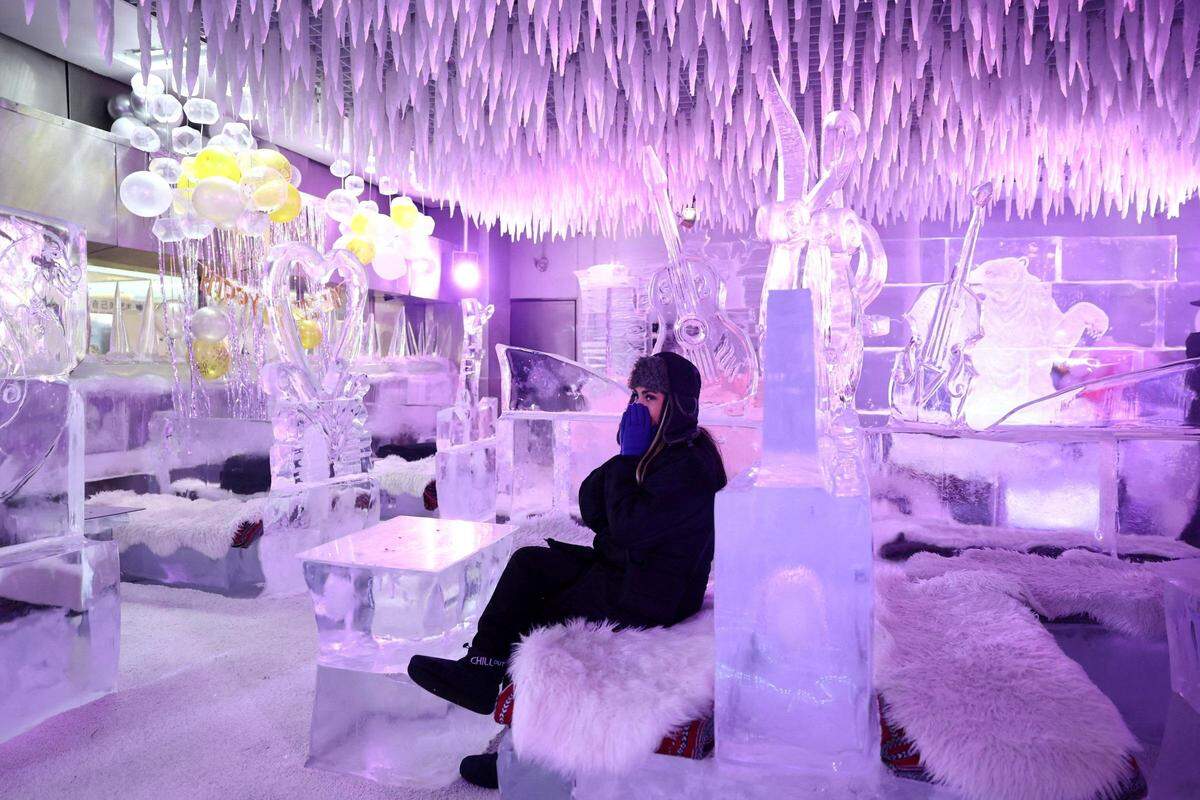 28. August. Ein Besucher sitzt auf den Kreationen des Eisbildhauers Mark Ranasinghe bei eisigen Temperaturen in der „Chillout Ice Lounge“ in Dubai.