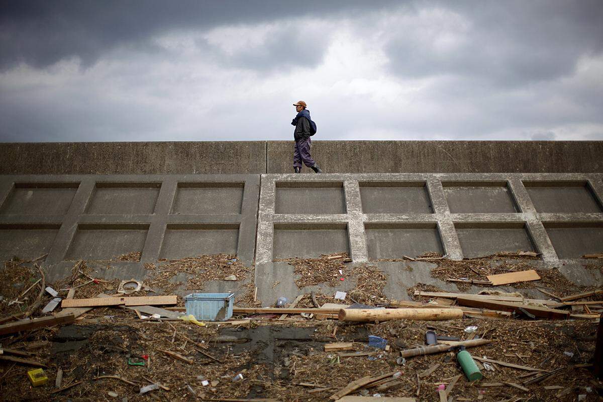 Ein Mann überschreitet die demolierte Hafenmauer in Miyako. (25. März)