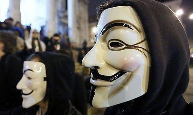 A protester wearing a Guy Fawkes mask, symbolic of the hacktivist group Anonymous, takes part in a 