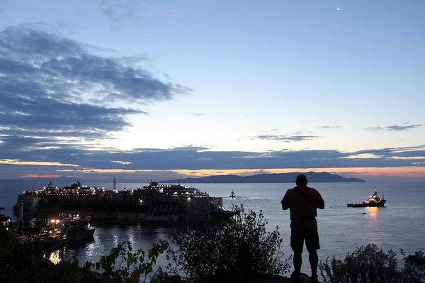 Am Mittwoch hatte die Costa Concordia ihre letzte Reise in den Hafen von Genua zur Verschrottung begonnen. Der letzte Sonnenaufgang: Zweieinhalb Jahre lang war die Costa Concordia ein groteskes Wahrzeichen, ein Mahnmal vor der Insel Giglio gewesen.