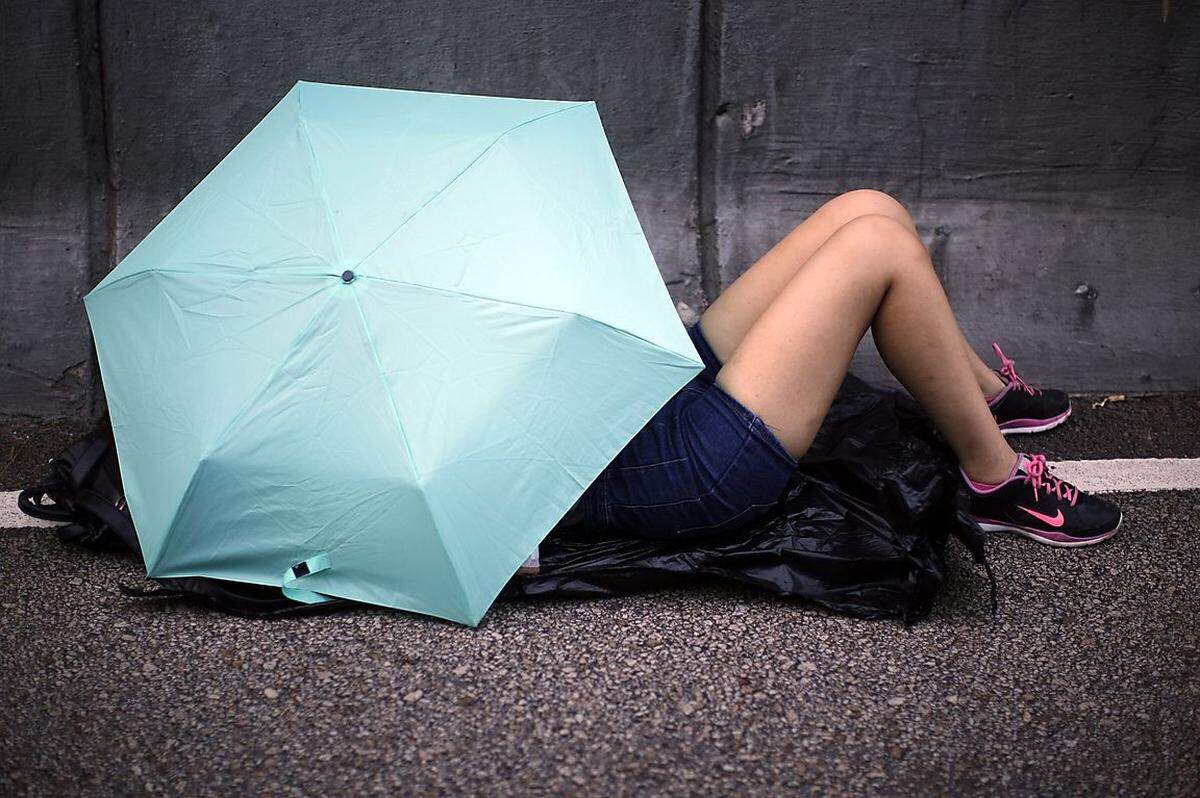 Auch um sich in einer Demonstrationspause kurz ein Refugium zum Ausruhen zu schaffen, erfüllt der Regenschirm seinen Zweck.