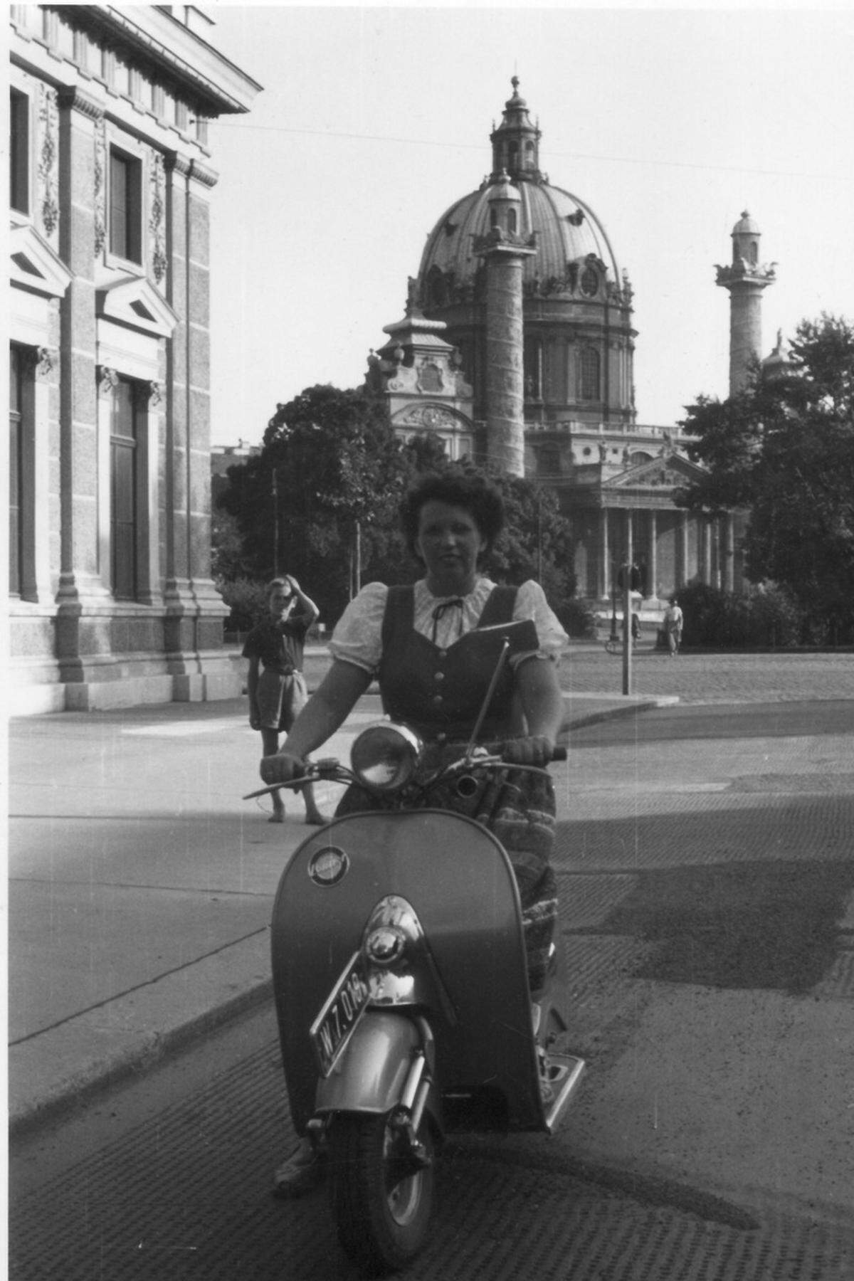 Eine Rollerfahrerin auf dem Lohner L 98 T vor der Wiener Karlskirche. Schutzkleidung war damals noch kein Thema.