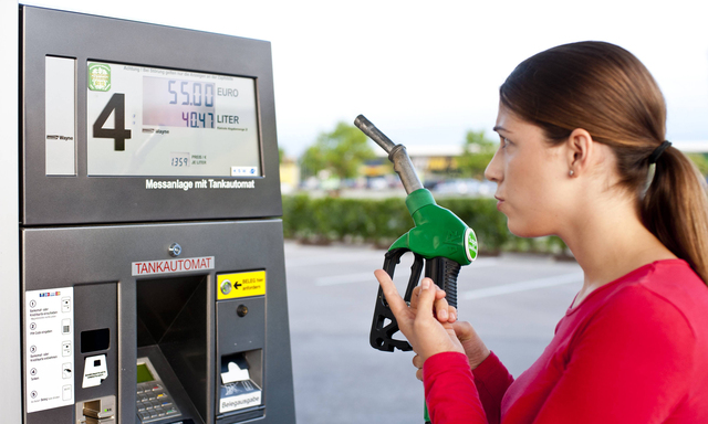 Junge Frau an einer Tankstelle mit Zapfpistole model released Copyright xKTHx ALLCB837676