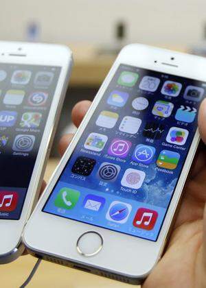 A man holds a new Apple iPhone 5S next to his iPhone 5 at an Apple Store at Tokyo´s Ginza shopping district