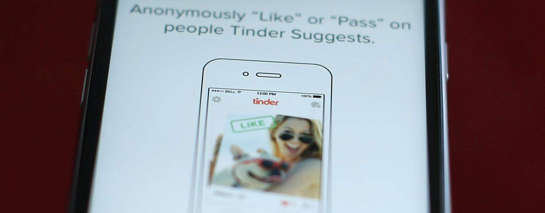 Photo illustration of dating app Tinder shown on an Apple iPhone