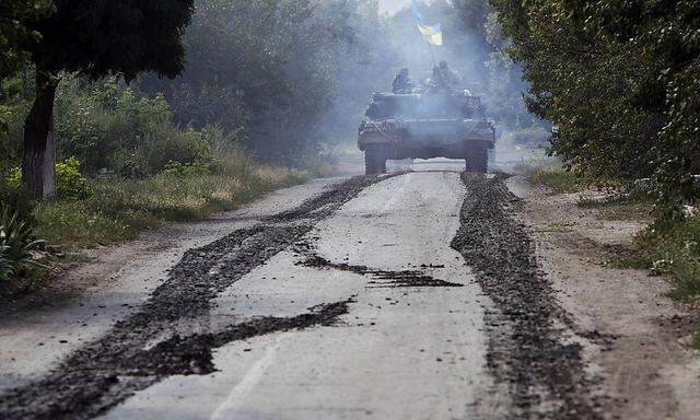 A Ukrainian tank moves along a road near Eastern Ukrainian village of Novoselivka Persha