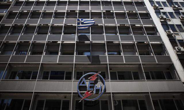 A Greek national flag flutters at the PPC headquarters building in Athens